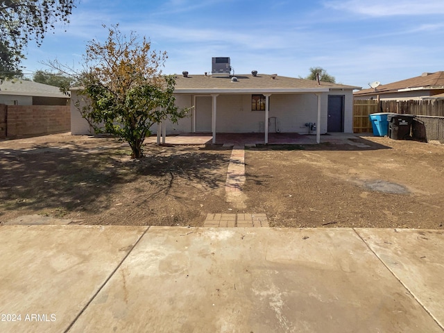rear view of property featuring fence and a patio area