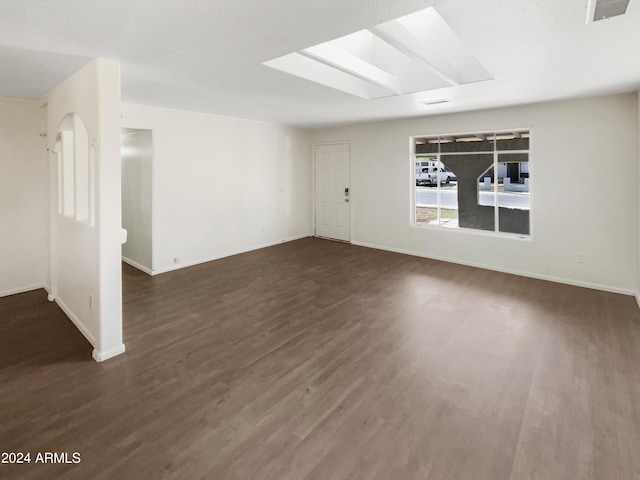 unfurnished room with baseboards and dark wood-style floors