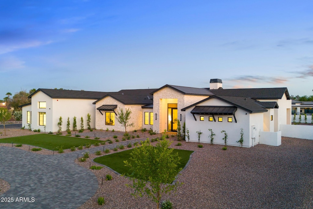 6147 E Desert Cove Ave, Scottsdale, AZ 85254 - view of front of house with a chimney, stucco siding, stone siding, and a standing seam roof