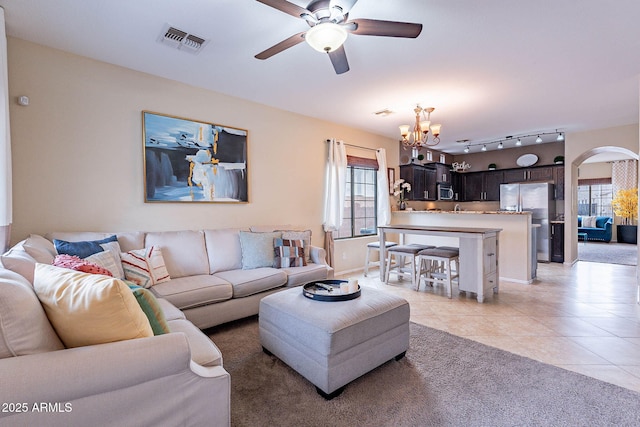 13318 W Indianola Ave, Litchfield Park, AZ 85340 - living room featuring ceiling fan, a chandelier, light tile patterned floors, arched walkways, and baseboards