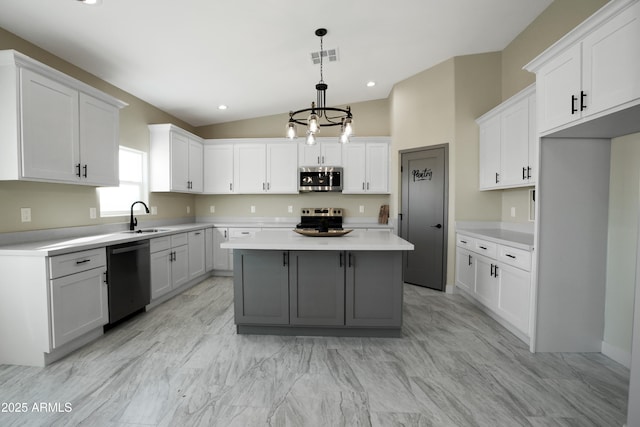 kitchen with visible vents, a sink, stainless steel appliances, light countertops, and a center island