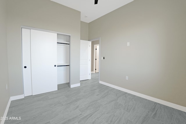 unfurnished bedroom featuring baseboards, a closet, and ceiling fan