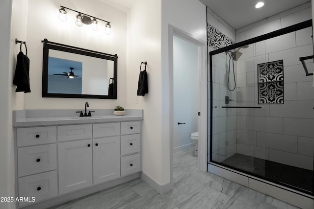 full bath with toilet, marble finish floor, a stall shower, baseboards, and vanity