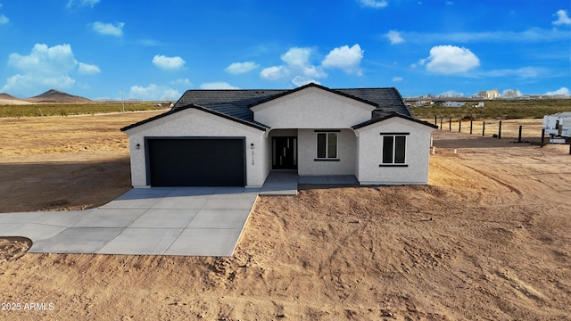 view of front of house featuring concrete driveway, a garage, and stucco siding