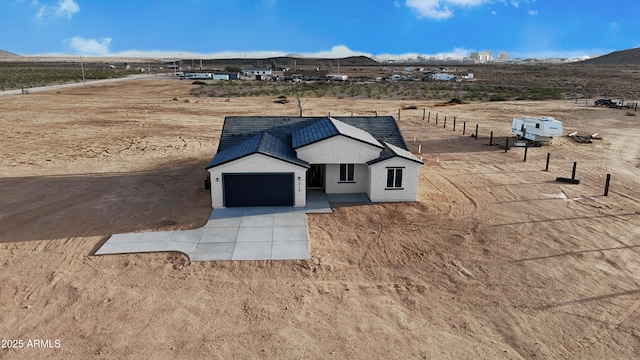 modern inspired farmhouse with fence, a mountain view, driveway, and stucco siding