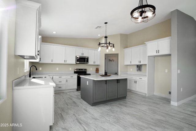 kitchen featuring a sink, white cabinets, a center island, and stainless steel appliances