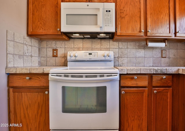 kitchen featuring decorative backsplash, brown cabinetry, and white appliances