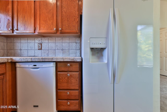 kitchen with tile counters, brown cabinetry, white fridge with ice dispenser, tasteful backsplash, and dishwashing machine