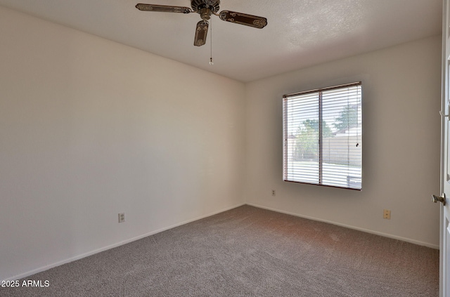 spare room with a ceiling fan, baseboards, and dark carpet