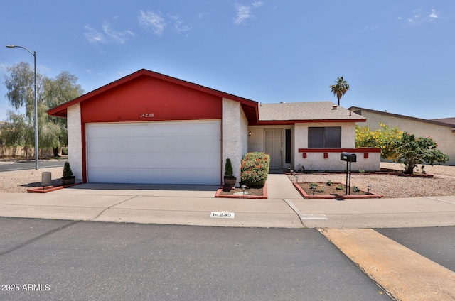 ranch-style house featuring a garage, stucco siding, and concrete driveway