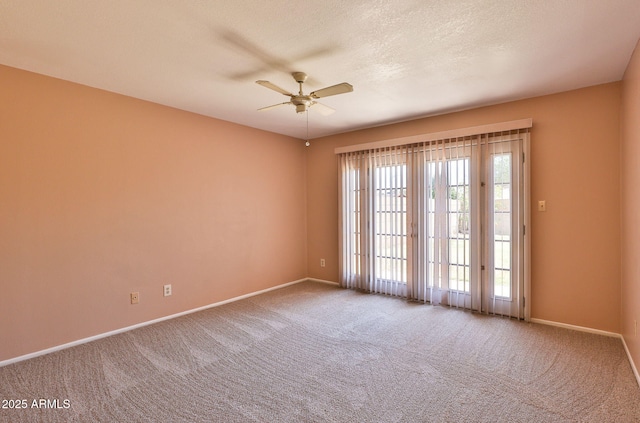 carpeted empty room with baseboards and ceiling fan