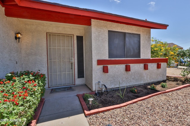view of exterior entry featuring stucco siding