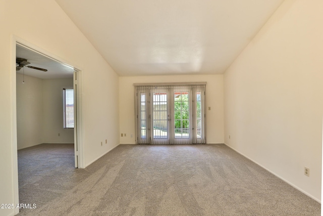carpeted spare room featuring ceiling fan and baseboards