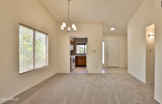 empty room with light tile patterned flooring, baseboards, a notable chandelier, and light carpet