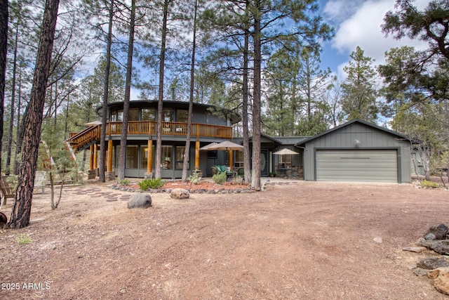 chalet / cabin featuring driveway, a garage, and stone siding