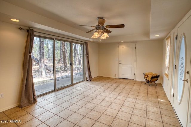 spare room with light tile patterned floors, ceiling fan, recessed lighting, a raised ceiling, and baseboards