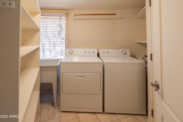 washroom with washer and dryer, light tile patterned floors, and laundry area