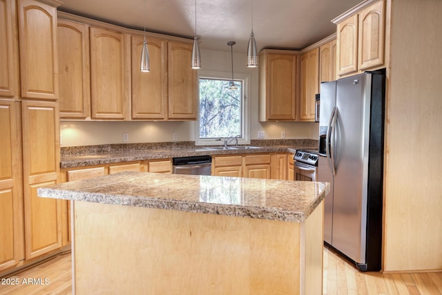 kitchen with a sink, appliances with stainless steel finishes, light brown cabinets, and light wood finished floors