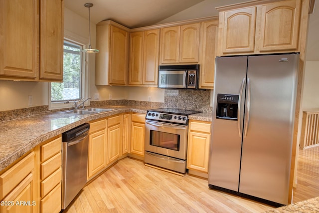 kitchen featuring light wood-type flooring, light brown cabinets, a sink, and appliances with stainless steel finishes