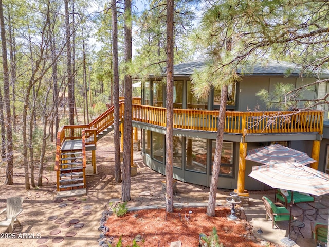 wooden deck with stairs and a sunroom