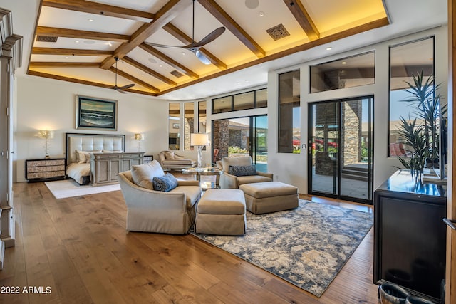 living room featuring dark hardwood / wood-style flooring, ceiling fan, beamed ceiling, and high vaulted ceiling