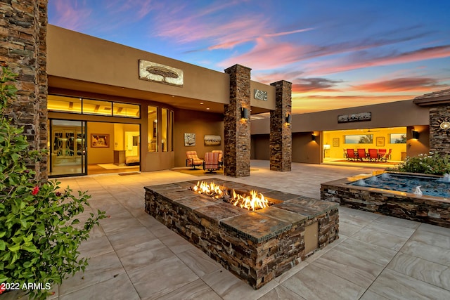 patio terrace at dusk featuring a fire pit