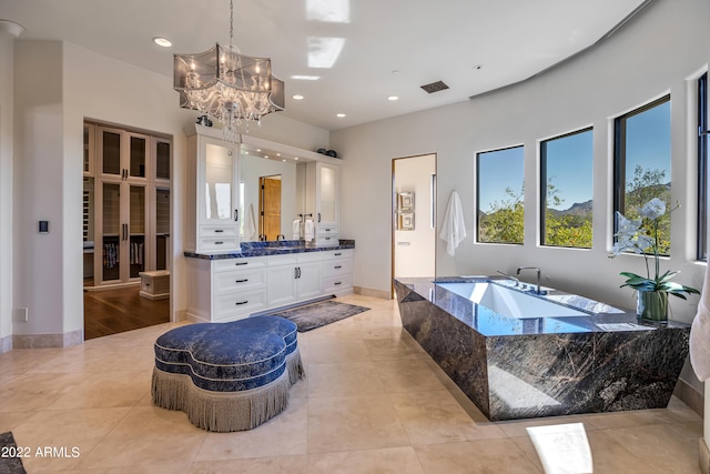 bathroom with hardwood / wood-style floors, a relaxing tiled bath, large vanity, and a chandelier