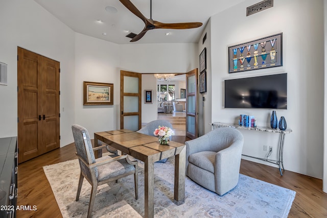 dining area featuring hardwood / wood-style floors, ceiling fan with notable chandelier, and lofted ceiling