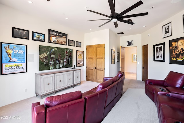 home theater room featuring ceiling fan and light colored carpet