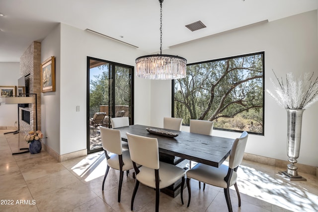 tiled dining area with a chandelier, a wealth of natural light, and brick wall