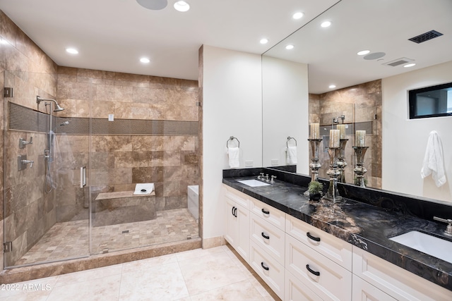 bathroom featuring walk in shower, tile flooring, double sink, and vanity with extensive cabinet space