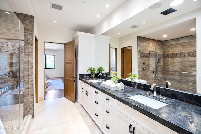 bathroom with oversized vanity, an enclosed shower, double sink, and tile flooring