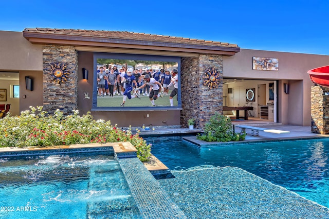 view of swimming pool with a diving board and a jacuzzi