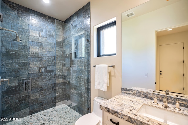 bathroom with a shower with shower door, oversized vanity, and toilet