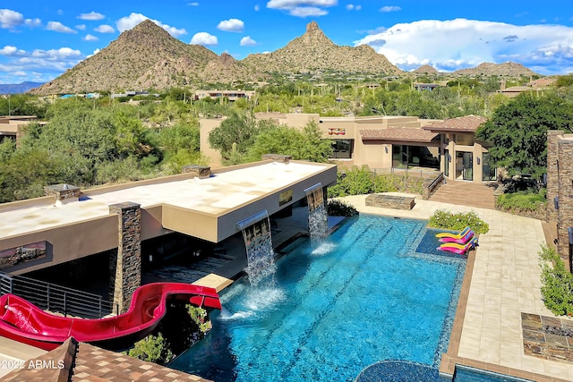 view of swimming pool with a patio and a mountain view