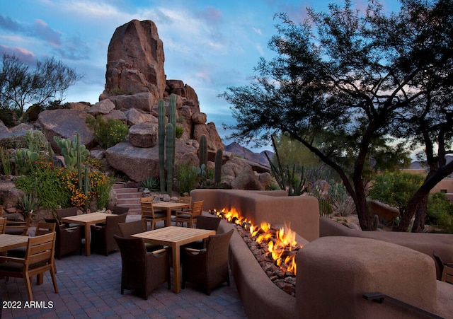 patio terrace at dusk with an outdoor fireplace