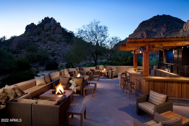 view of terrace with an outdoor bar, an outdoor hangout area, and a mountain view