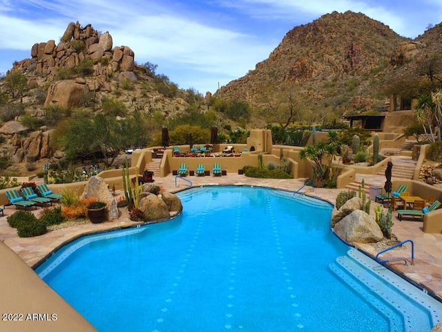 view of pool featuring a patio area and a mountain view