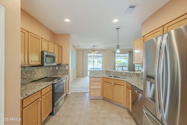 kitchen with pendant lighting, sink, decorative backsplash, ceiling fan, and stainless steel appliances