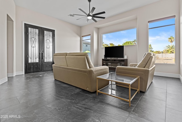 living room featuring french doors and ceiling fan