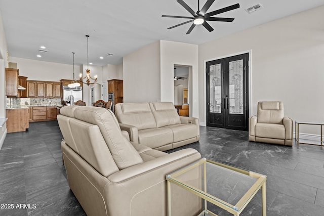 living room featuring sink, ceiling fan with notable chandelier, and french doors