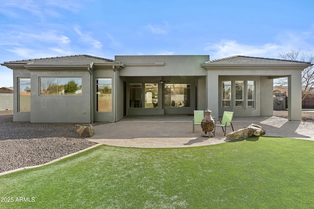 back of property featuring ceiling fan, a yard, and a patio area