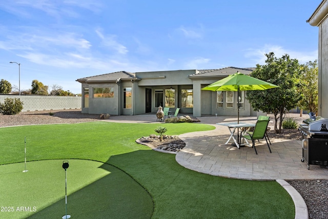 rear view of property with a yard and a patio area