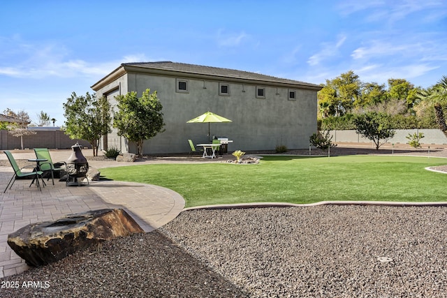 back of house featuring a lawn and a patio