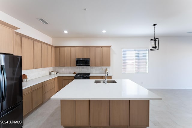 kitchen with a kitchen island with sink, tasteful backsplash, decorative light fixtures, sink, and black appliances