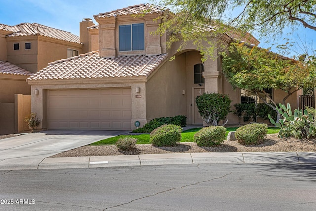 mediterranean / spanish home with a tiled roof, driveway, and stucco siding