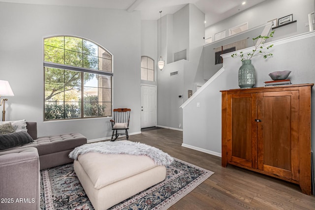 living room with visible vents, baseboards, stairway, a towering ceiling, and dark wood-style floors