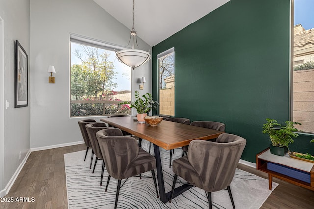 dining area with baseboards, lofted ceiling, and wood finished floors