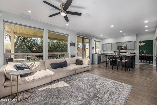 living area with recessed lighting, a ceiling fan, and dark wood-style flooring