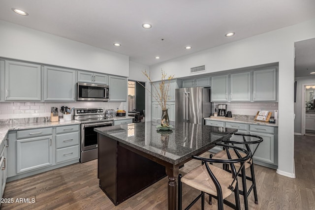 kitchen featuring dark wood finished floors, visible vents, gray cabinets, and stainless steel appliances